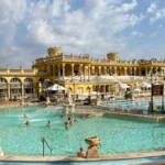 Széchenyi thermal bath outdoor pool with yellow Neo-Baroque building — terme Budapest