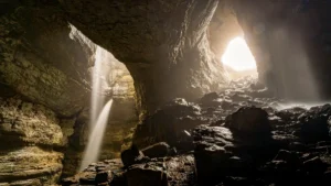 Apache Death Cave photos showing dark cave interior with waterfall and light streaming through Canyon Diablo